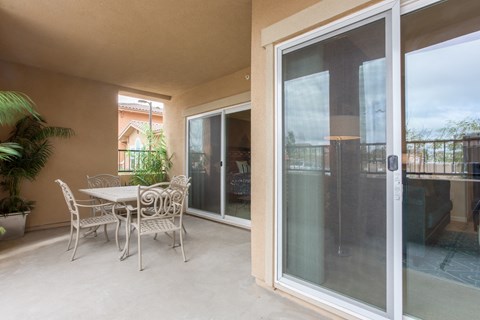 a patio with a table and chairs and a sliding glass door
