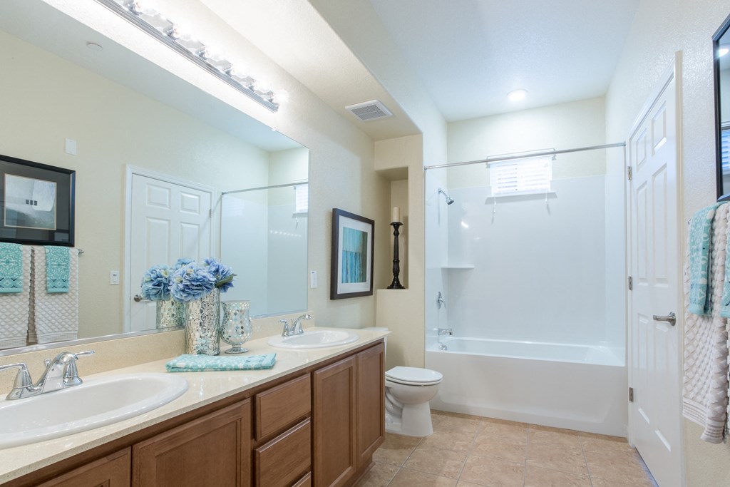a bathroom with two sinks and a shower and a toilet