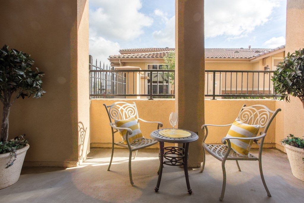 a patio with chairs and a table on a balcony