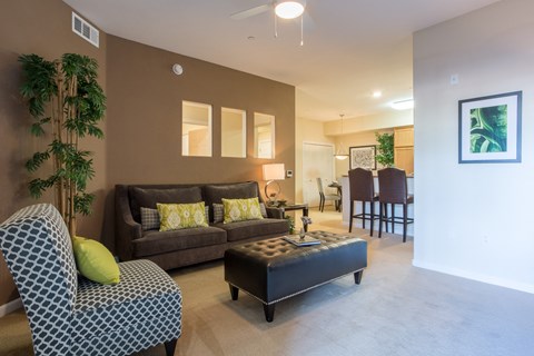 a living room with a couch and a coffee table in front of a dining room