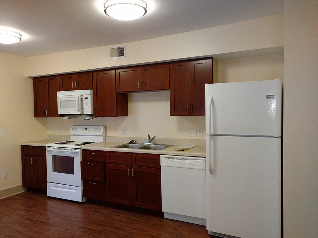 a kitchen with white appliances and wooden cabinets