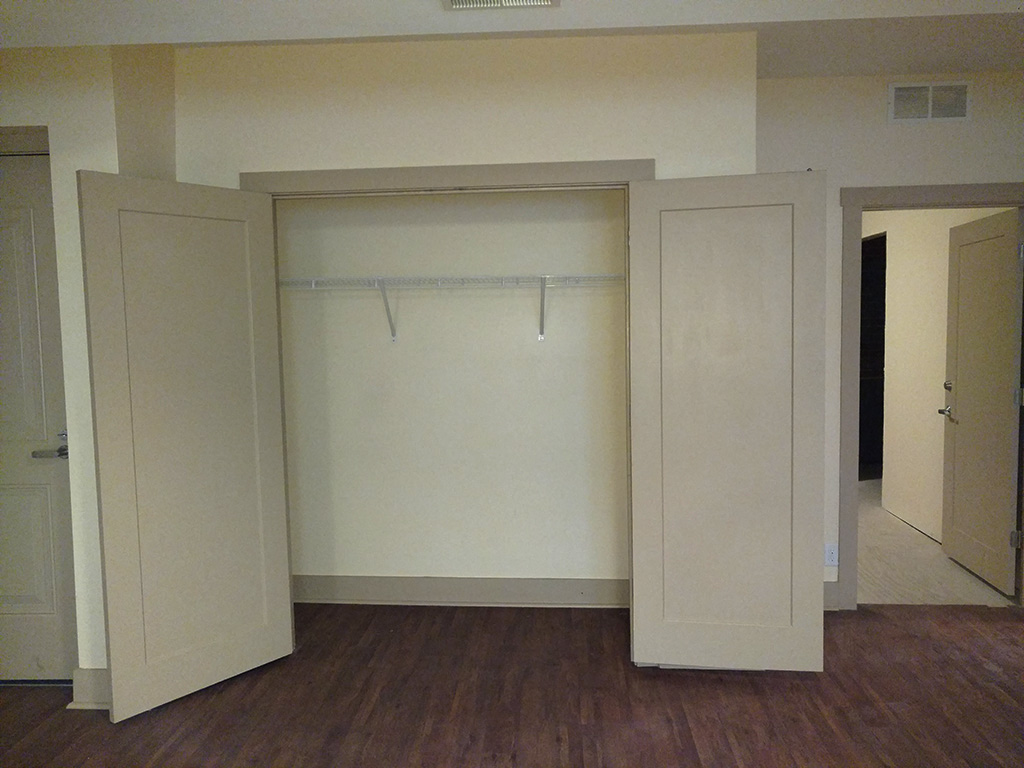 an empty room with a closet and a door