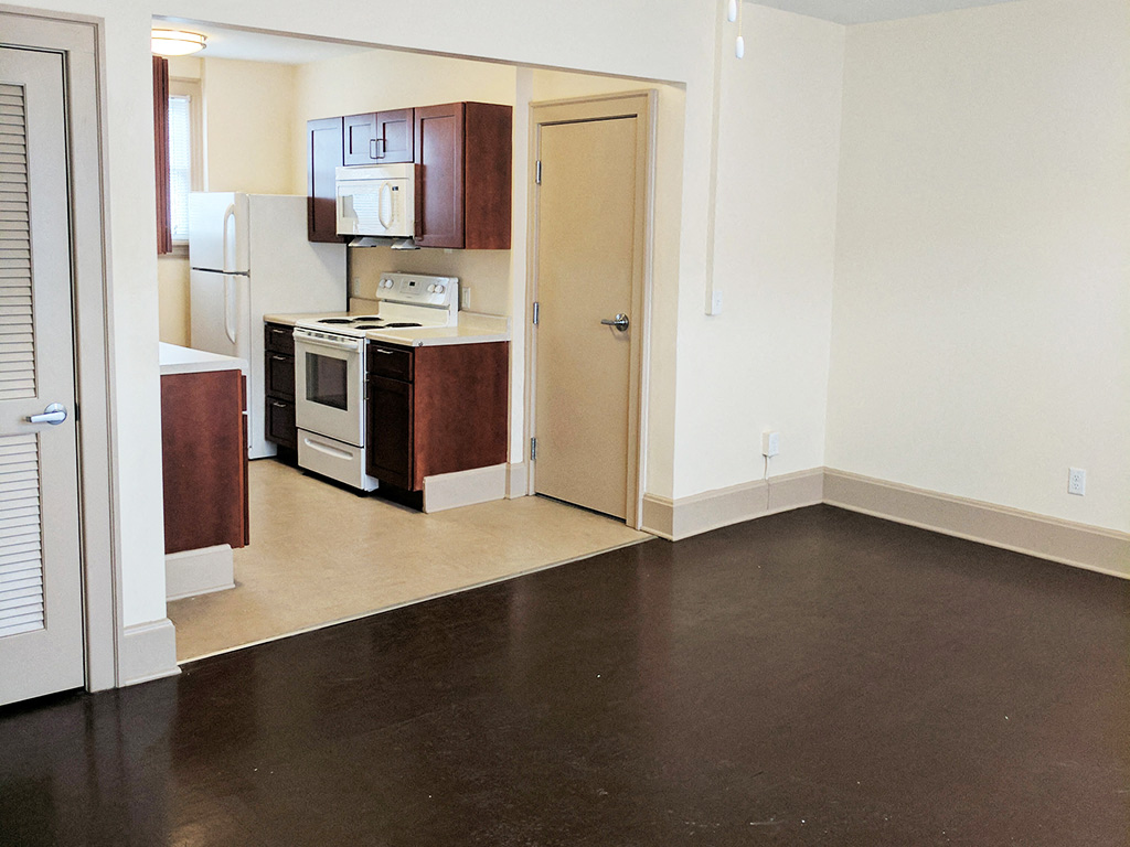 a view of a kitchen and a living room with a dark floor