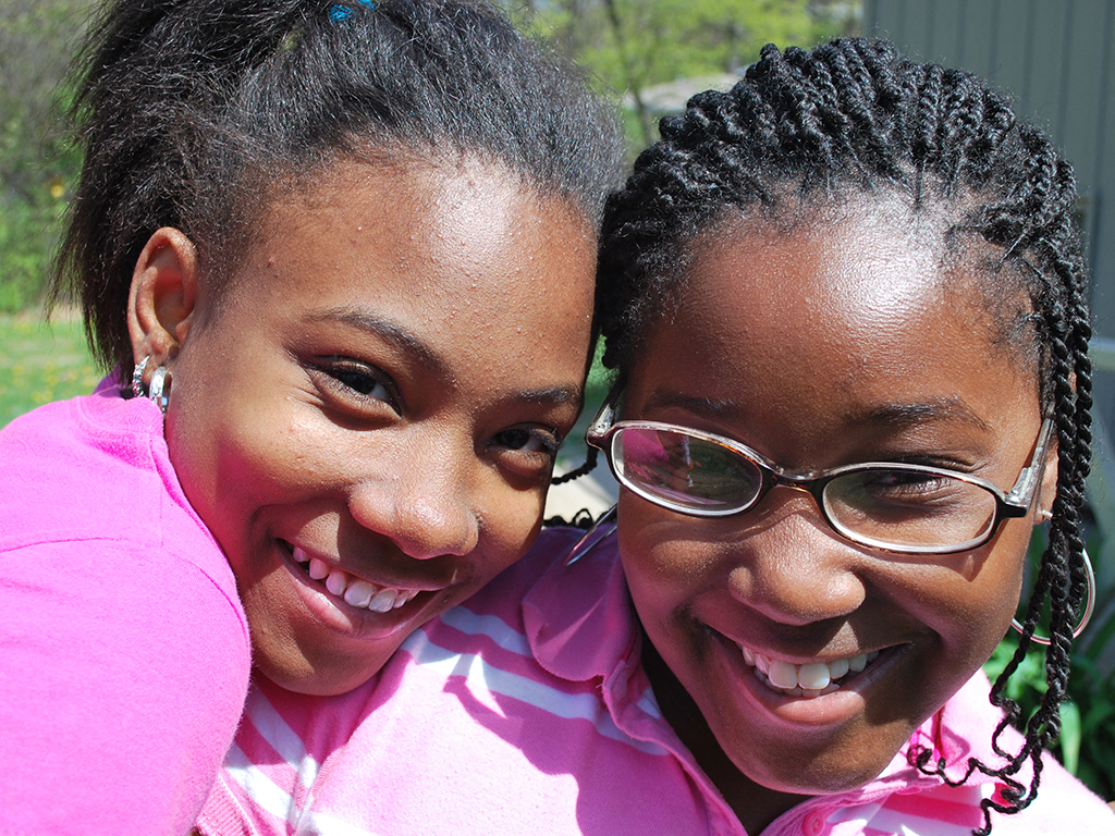 two young girls smiling and hugging each other