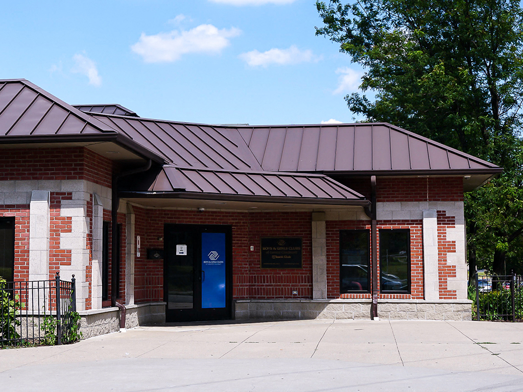 a brick building with a blue door and a metal roof