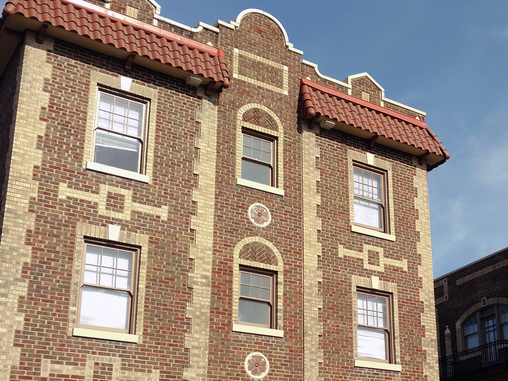 a brick building with windows and a blue sky