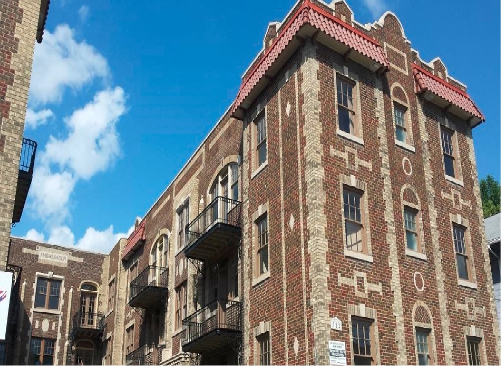 an old brick building with balconies and a blue sky