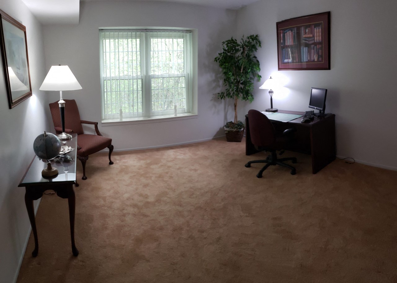 a home office with a desk and chair and a window