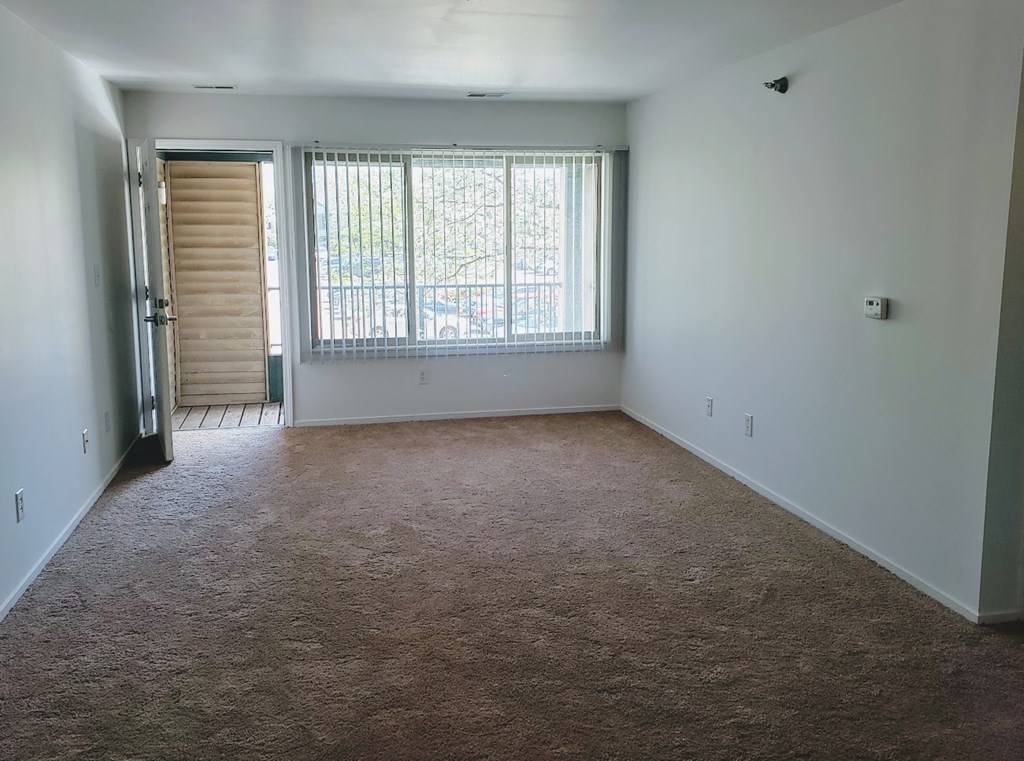 an empty room with a window and a door