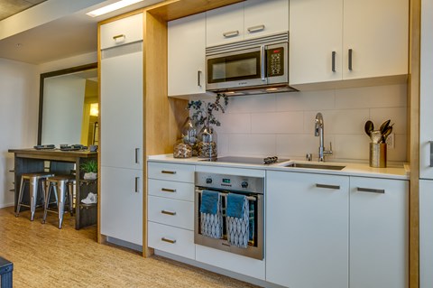 a kitchen with white cabinets and a sink and a microwave