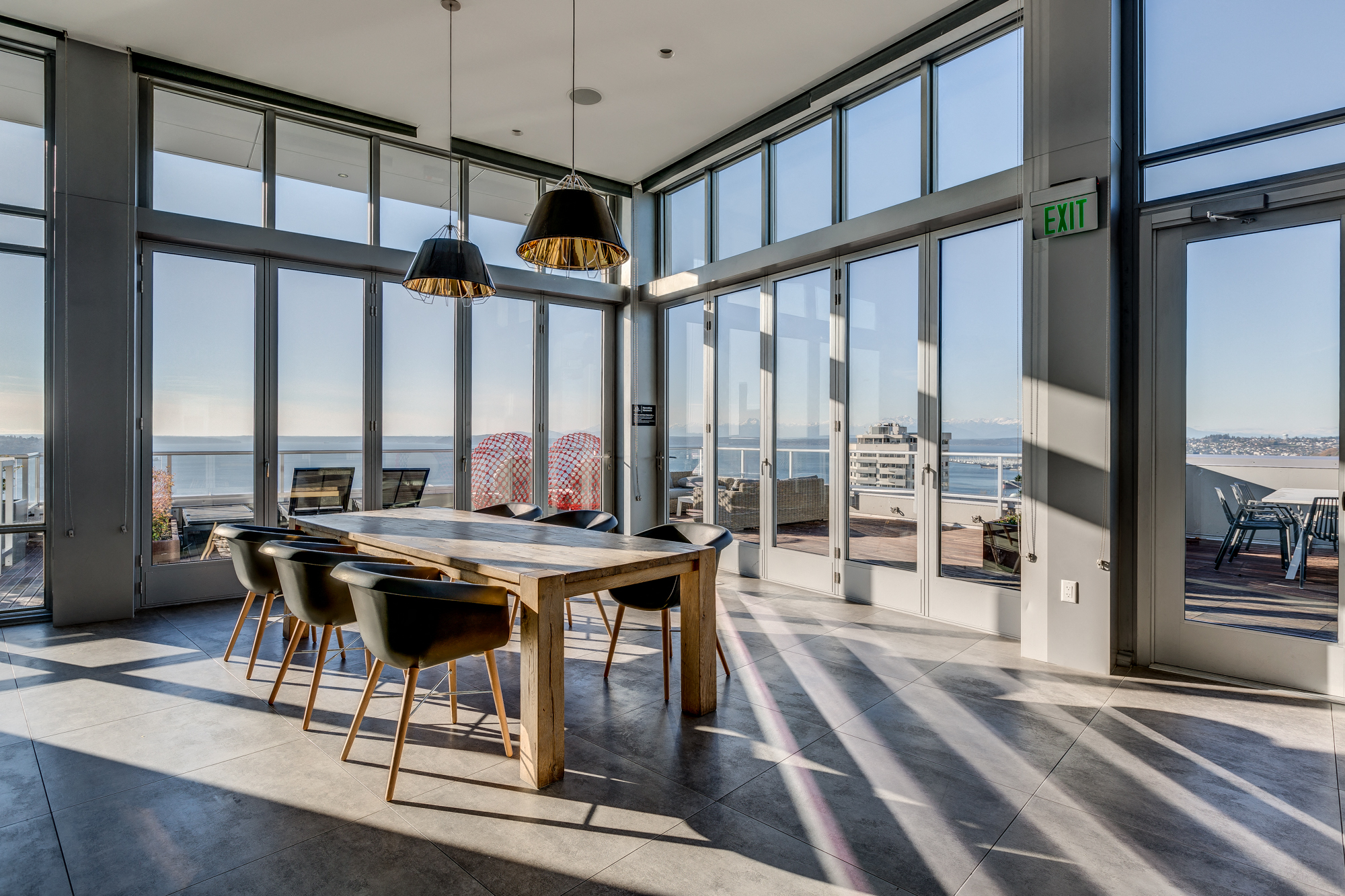 a dining area with a wooden table and chairs and a view of the ocean from