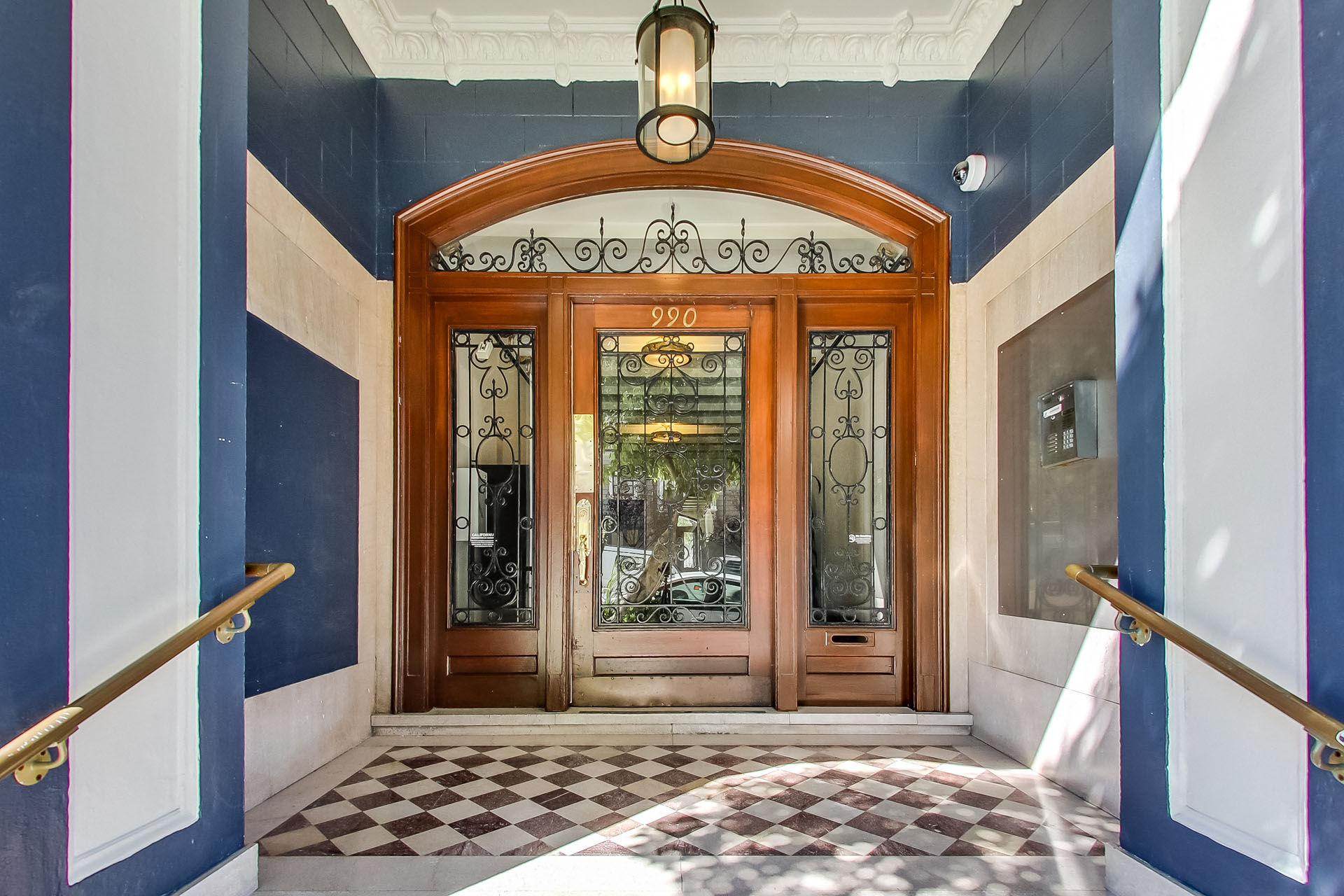 A wooden door with glass panels and a sign above it that reads "990".