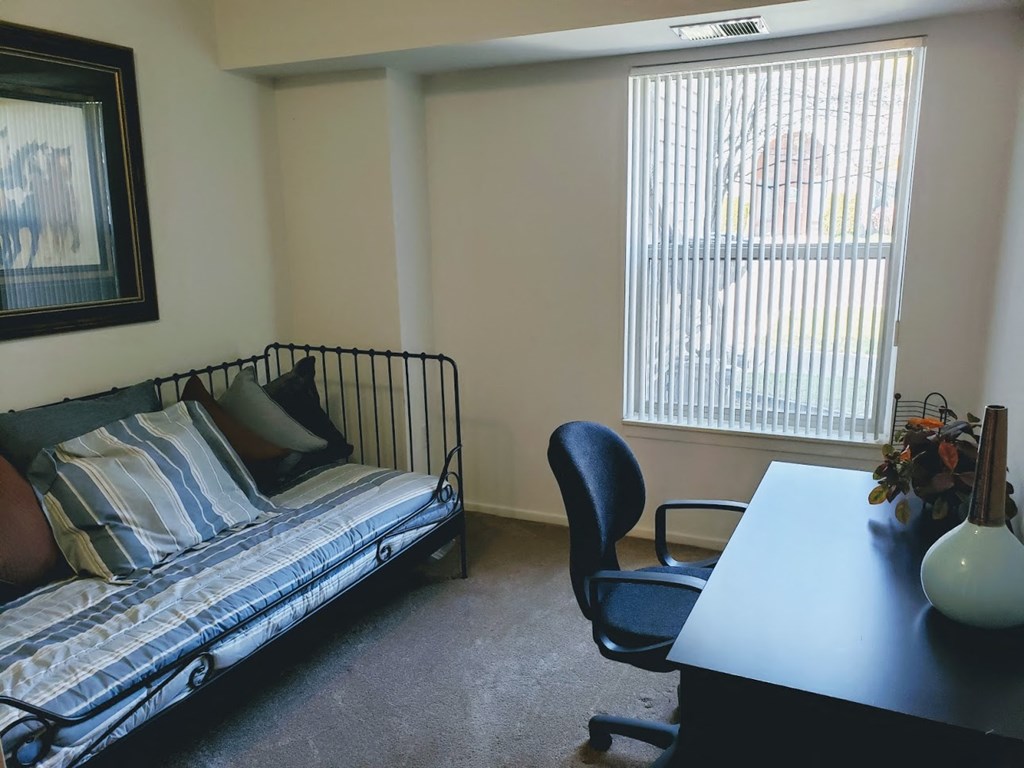 an example of a living room with a bed and a desk