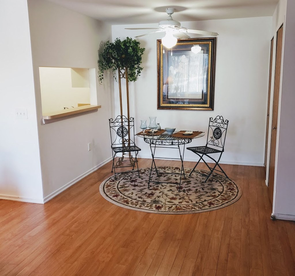 a dining room with a table and chairs and a mirror on the wall