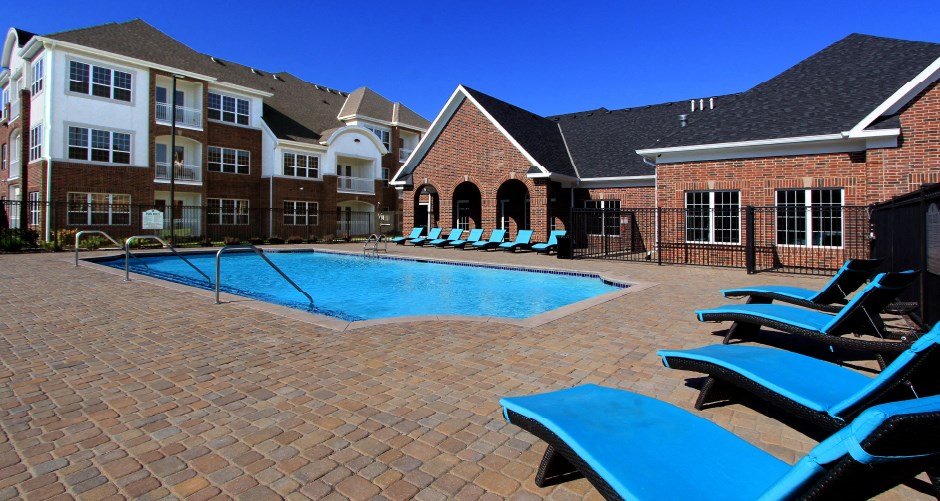 Luxury apartments with swimming pool, poolside lounges, and brick exteriors at Bellemeade Apartments in west Des Moines