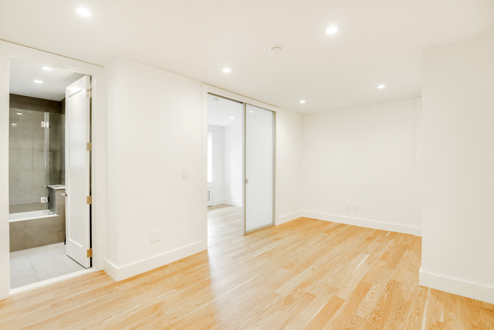 a living room with a hard wood floor and white walls