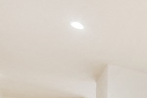 the living room and dining room of a house with white walls and wood floors