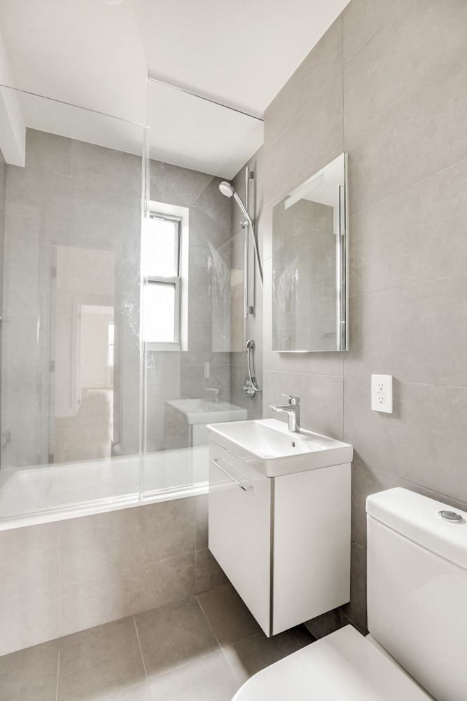 A white bathroom with a toilet, sink, and bathtub.