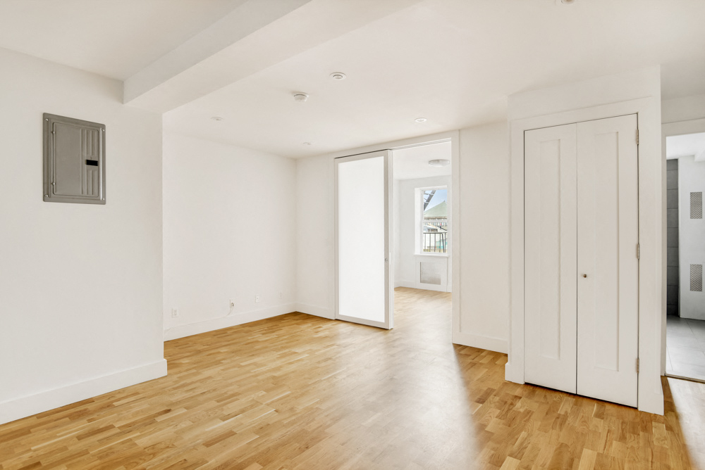 an empty living room with white walls and wood floors