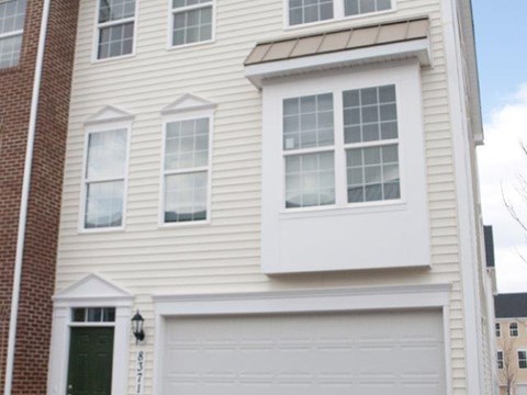 a white house with white siding and a garage
