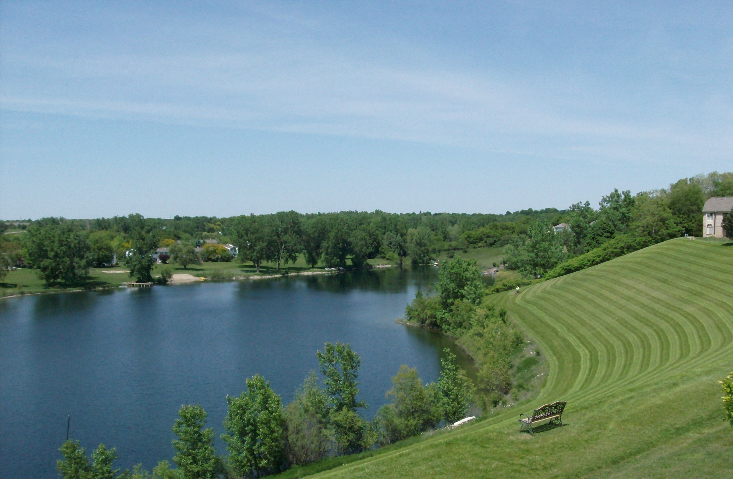 a view of a lake and a grassy field with a building on the side