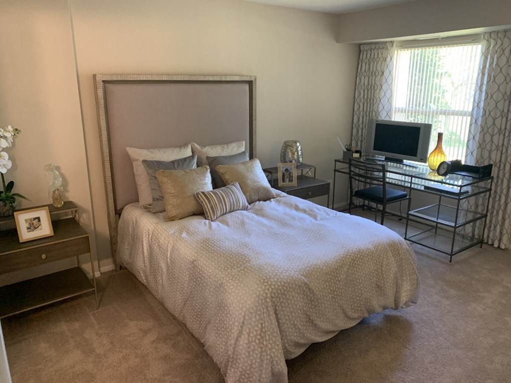 a bedroom with a bed and a desk with a tv