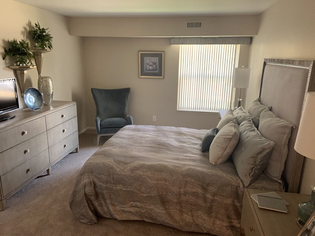a bedroom with a bed and a dresser and a window