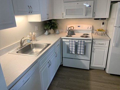 a kitchen with white cabinets and a stove and a sink