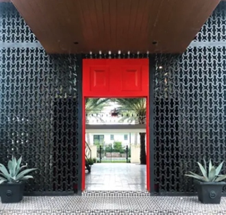 a red door leading to a courtyard with plants