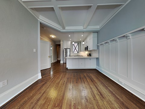 a kitchen with white cabinets and a wood floor