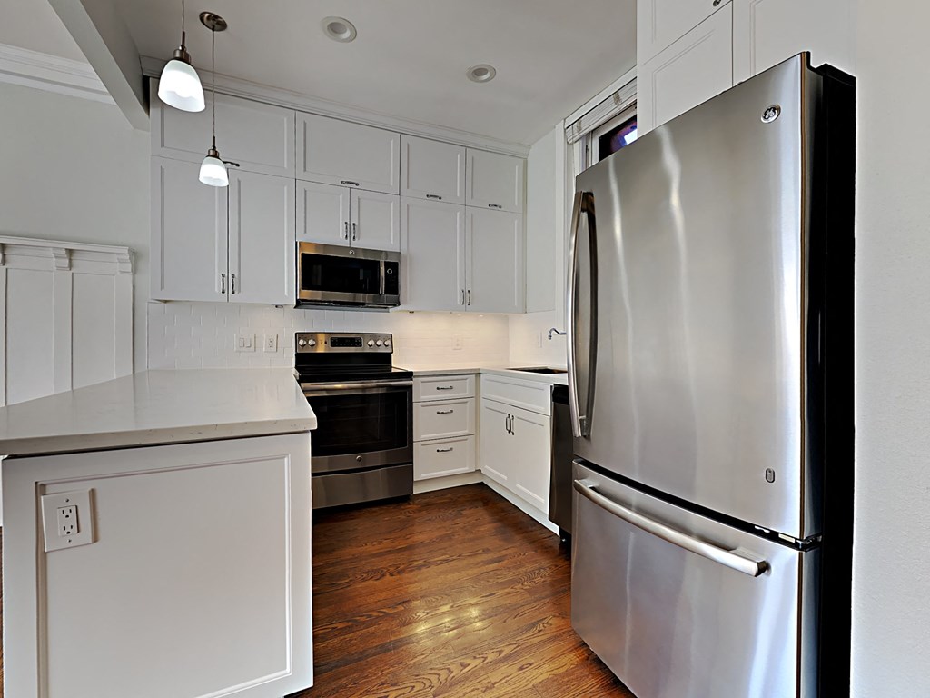 a kitchen with stainless steel appliances and white cabinets