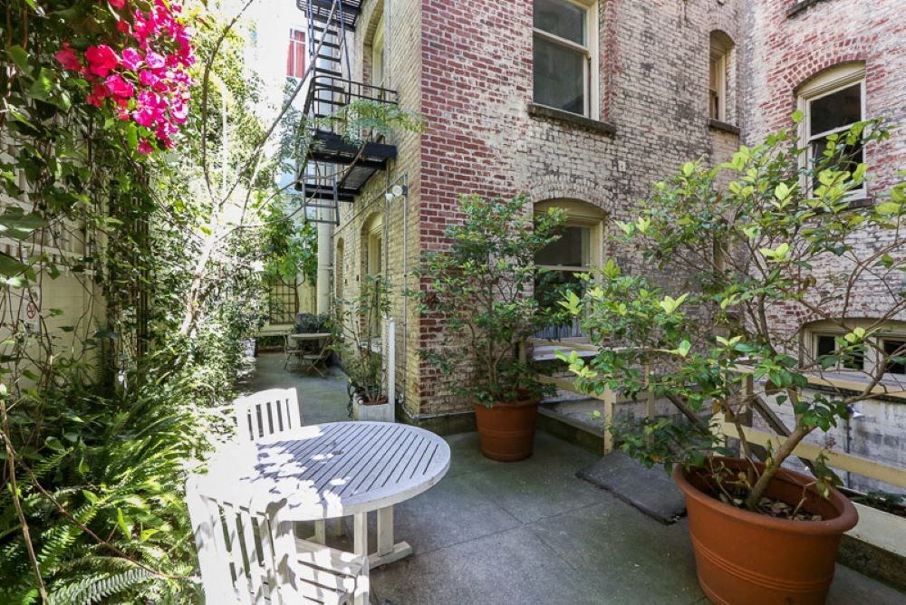 a small patio with a white table and chair and potted plants