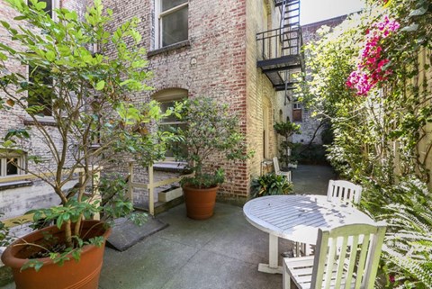 a small patio with a table and chairs and plants