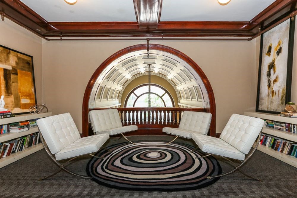 a group of white chairs in a room with a large window