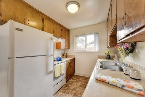 a kitchen with white appliances and a sink and a refrigerator