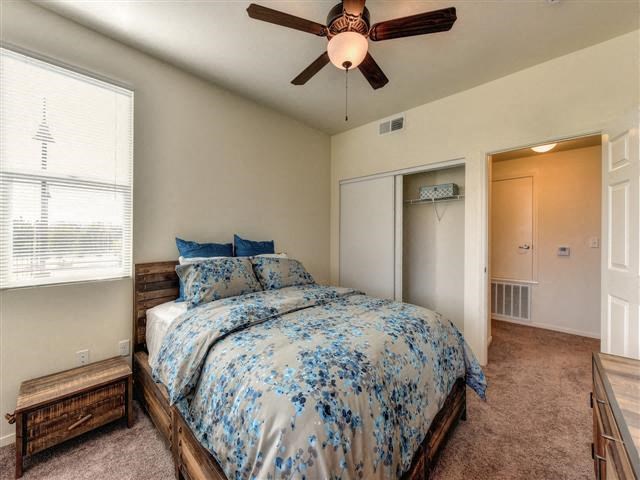 a bedroom with a bed and a ceiling fan