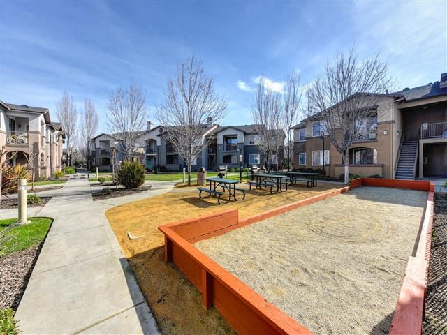 a large yard with a playground and picnic tables
