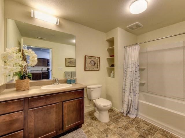a bathroom with a toilet and a sink and a shower