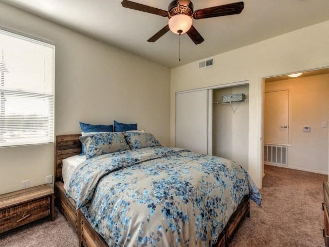a bedroom with a bed and a ceiling fan