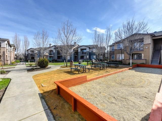 a playground with picnic tables in front of houses
