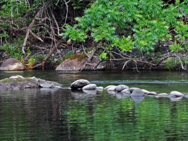 a group of rocks on the water in a river