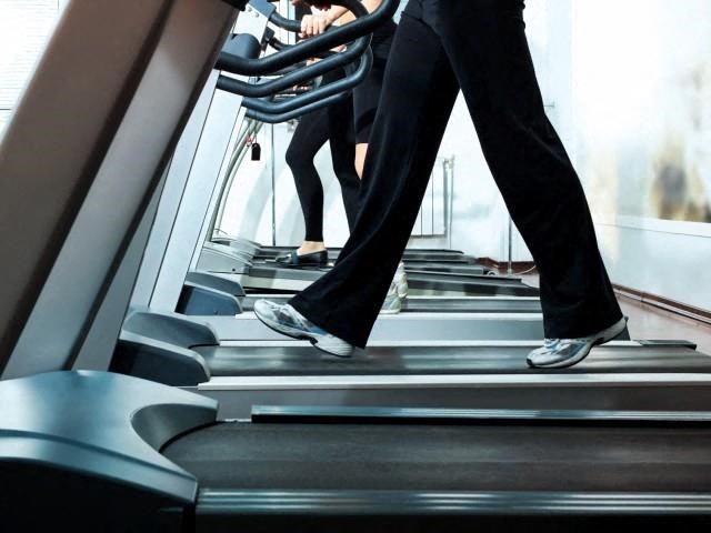 a couple of people walking on a treadmill