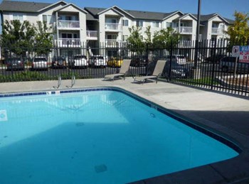 Heron Creek Apartments l pool with lounge chairs - Photo Gallery 8