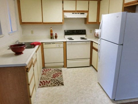 a kitchen with white appliances and a white refrigerator