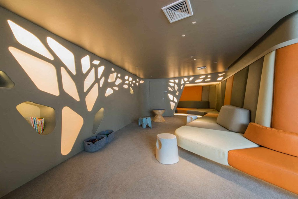 a room with a couch and a tree on the wall