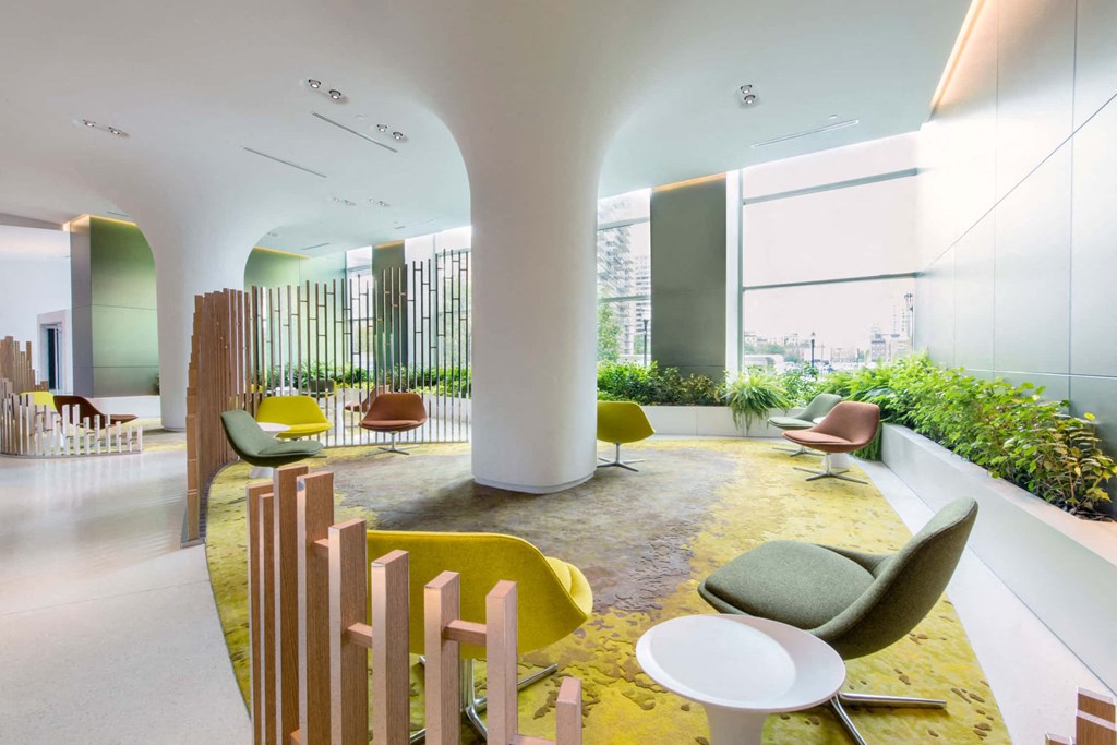 a lobby with chairs and tables and a large window