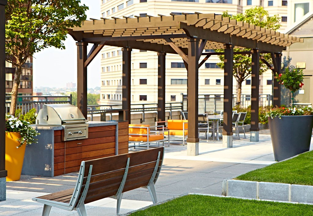 a picnic area with benches and a pergola on a rooftop