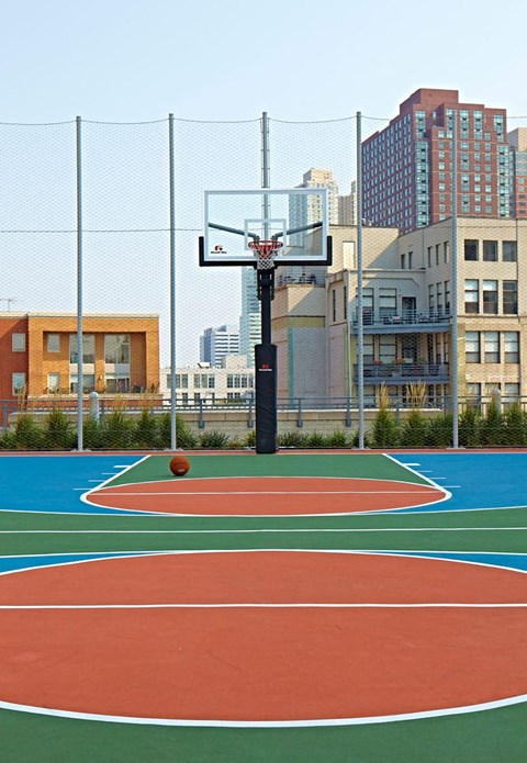 a basketball court with buildings in the background