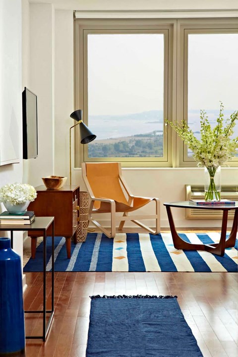 a living room with a chair and a view of the ocean
