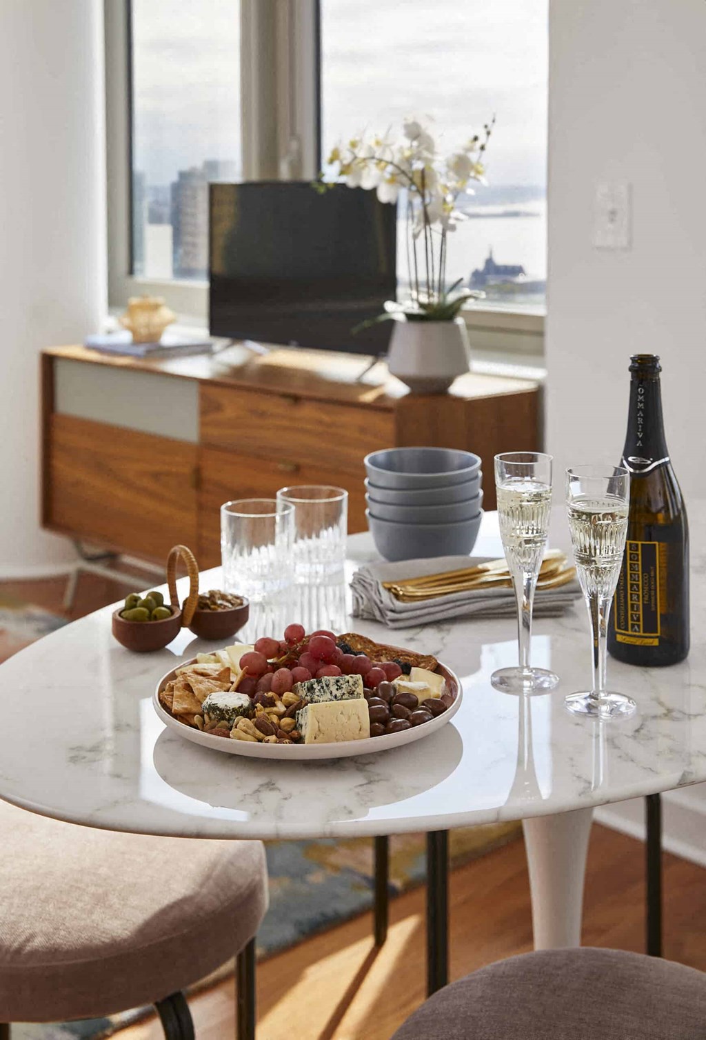 a table with a plate of food and wine on it